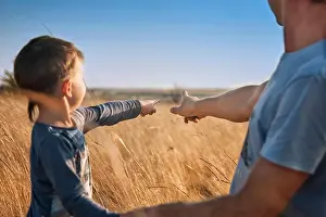 Fatherhood Prints: Father and son in the field at sunset