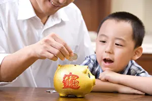 Affectionate Prints: Father and son saving coins into a piggy bank