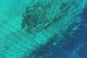 Images Dated 28th June 2019: Father and son snorkels through tropical, turquoise waters, aerial view