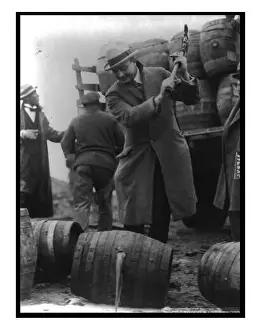 Part Prints: FBI Officer breaks a confiscated barrel of beer as part of the prohibition campaign against alcohol in the USA
