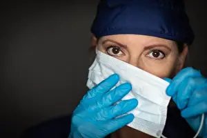 Scrubs Prints: Female Doctor or Nurse Wearing Surgical Gloves Putting On Medical Face Mask