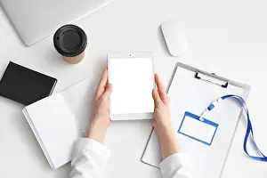 Examination Prints: Female doctor working with tablet computer on table in clinic, top view