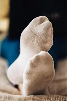 Holiday House Prints: Female feet in white dirty socks on bed with laptop - work from home