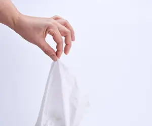 Thumb Prints: female hand holding a clean white paper napkin for face and body, white background