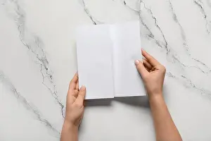 Read Prints: Female hands with blank brochure on white background