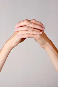 Strong Prints: Female hands held upwards fingers interlocked together illustrating strength unity determination fortitude reliability