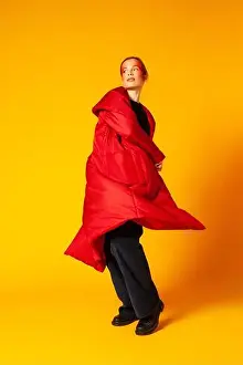 Full Body Prints: Female model in baggy coat spinning around against yellow background