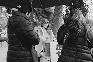 Eco Friendly Prints: Female visitors purchase shika senbei from a vendor with a small stall in Nara Park in black and white