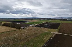 Cornfield Prints: Fields in winter with puddles, mud and taunus in the heavily cloudy background