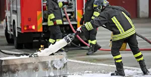 Firefighter Prints: Firefighter training and extinguishing with foam and fire truck on the background