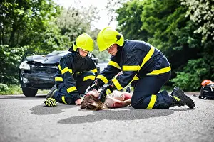 Lying Down Prints: Firefighters helping a young injured woman after a car accident