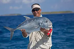 Tahiti Prints: Fisherman holding a giant trevally fish (Caranx ignobilis); Tahiti