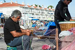 Repairing Prints: Fishermen repairing fishing nets at the water's edge in Foca, Turkey