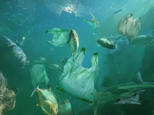 Plastic Pollution Prints: Fishes swimming among plastic garbage in sea. Environmental pollution