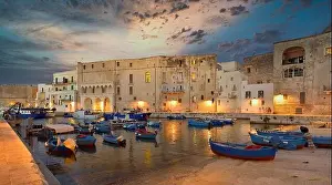 Fishing boats in Monipoli city bay with cloudy sky background, southern Italy, Europe