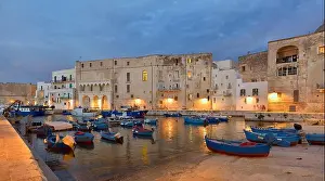 Fishing boats in Monipoli city bay with cloudy sky background, southern Italy