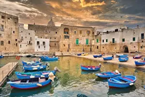 Fishing boats in Monipoli city bay with cloudy sky background, southern Italy, Europe