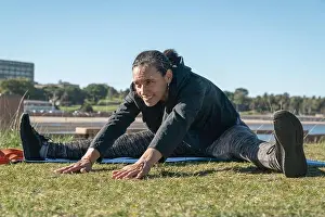 Flexibility Prints: Fitness woman stretching legs on exercise mat outdoors in a sunny day