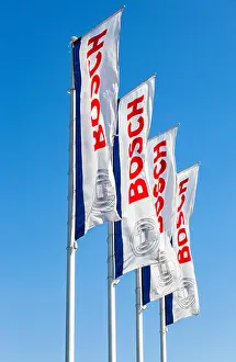 Flags with emblem Bosch against the blue sky