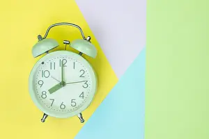 Wake Prints: Flat lay vintage alarm clock on sweet pastel colored paper top view