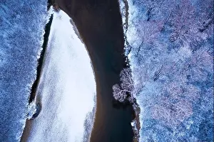Flight through majestic river, frozen forest and frosty winter fields at sunrise time. Landscape photography