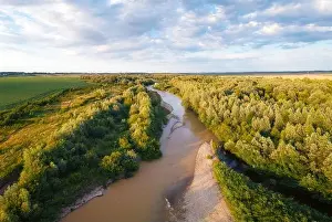 Flight through majestic river and lush green forest at sunset time. Landscape photography