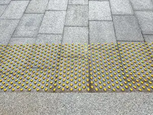floor tactile indicators on sidewalk to guide vision impaired person. surface for visually impaired