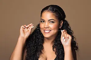 Dentistry Prints: Flossing concept. Beautiful brazilian chubby woman using dental floss