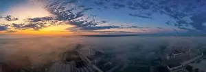 Awakening Prints: Foggy morning sunrise view over a business district with office buildings covered by the upcoming fog of the early