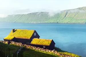 Foggy morning view of a house with grass roof in the Velbastadur village on Streymoy island, Faroe islands, Denmark. Landscape photography