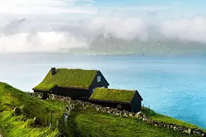 Foggy morning view of a house with grass roof in the Velbastadur village on Streymoy island, Faroe islands, Denmark. Landscape photography