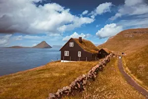 Foggy morning view of a house with typical turf-top grass roof in the Velbastadur village on Streymoy island, Faroe islands, Denmark
