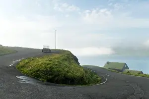 Foggy morning view of a house with typical turf-top grass roof in the Velbastadur village on Streymoy island, Faroe islands, Denmark. Landscape photog