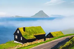 Foggy morning view of a house with typical turf-top grass roof in the Velbastadur village on Streymoy island, Faroe islands, Denmark