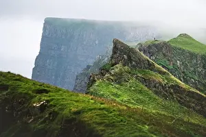 Holmur Prints: Foggy view of gorgeous mountains of Mykines island with tourist on high viewpoint