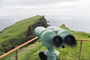 Images Dated 5th August 2019: Foggy view of old lighthouse from viewpoint with tourist binoculars on the Mykines island
