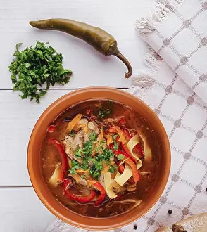Hull Prints: Food, Chicken soup with vegetables in brown bowl on white wooden table with pepper mill
