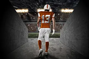 Team Sport Prints: Football Player with a orange uniform walking out of a Stadium tunnel