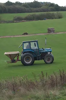 Turf Prints: Ford tractor spreading artificial fertiliser on turf growing farm, UK