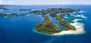 Forest-covered limestone islands rise from the seascape in Raja Ampat, Indonesia. This remote region is known for its great marine biodiversity