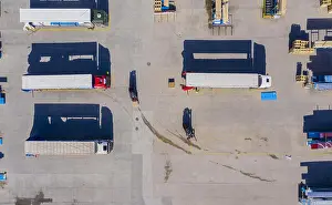 Rack Prints: Forklift is putting cargo from warehouse to truck outdoors. Aerial. top view