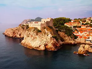 Dubrovnik Prints: Fortress on cliff surrounded by sea and red-tiled houses
