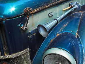 Headlight Prints: Fragment of shiny blue retro car with a signal horn outside and splattered with dirt