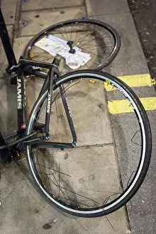 Stripped Prints: A frame and two wheel locked to a lamp post are all that remains of a bicycle which has been stripped of its parts