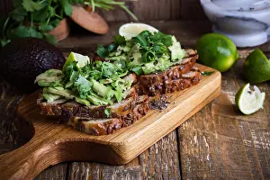 Toast Prints: Fresh avocado toasts with cilantro on rustic wooden cutting board