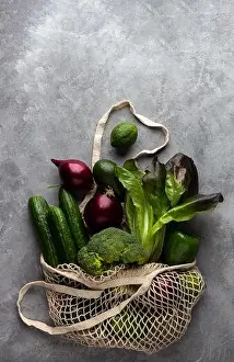Zero Waste Prints: Fresh vegetables and fruits in a string bag on a concrete background