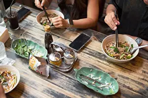 Noodles Prints: Friends eating together in restaurant high angle view closeup shot