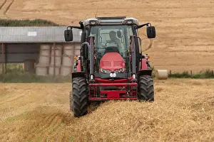 Arable Prints: A Front, or Head-On, View of a Farmer Baling Straw in a Field of Stubble