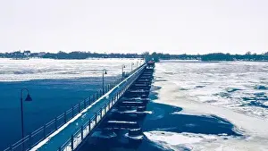 The frozen landscape with hiking/walking trail bridge over the frozen water