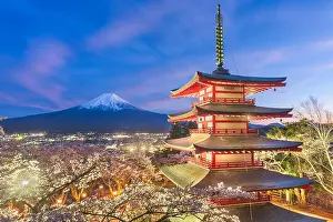 Fujiyoshida, Japan view of Mt. Fuji and pagoda in spring season with cherry blossoms at dusk